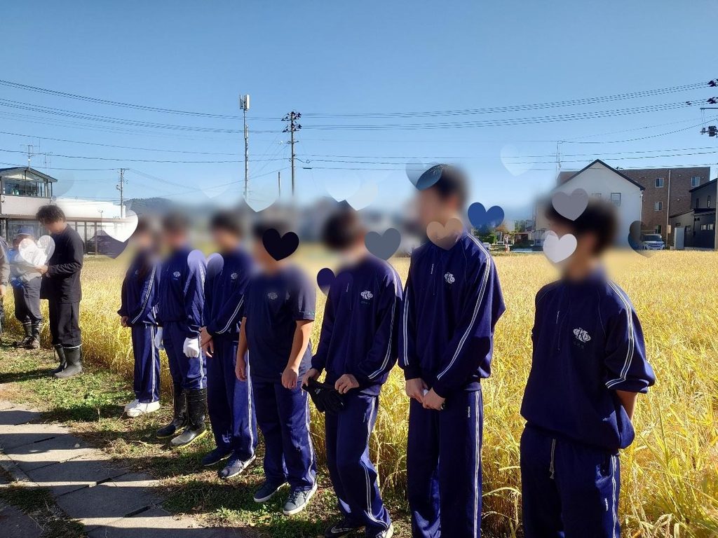 インターアクト部から７名が稲刈りに参加した。金色に実った田んぼの前で開会式をしている様子。